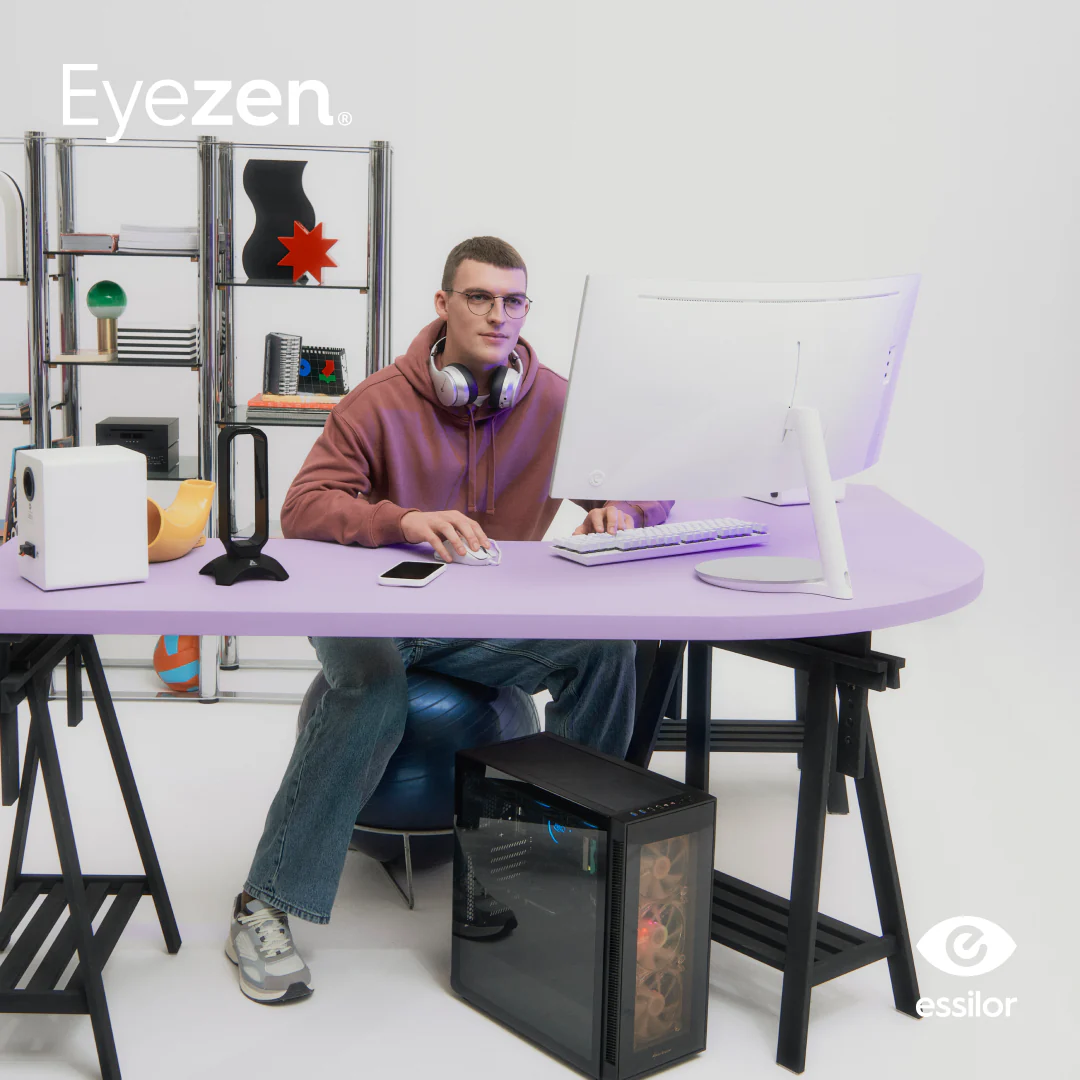 Người đeo kính Eyezen làm việc trước màn hình với logo Eyezen và Essilor